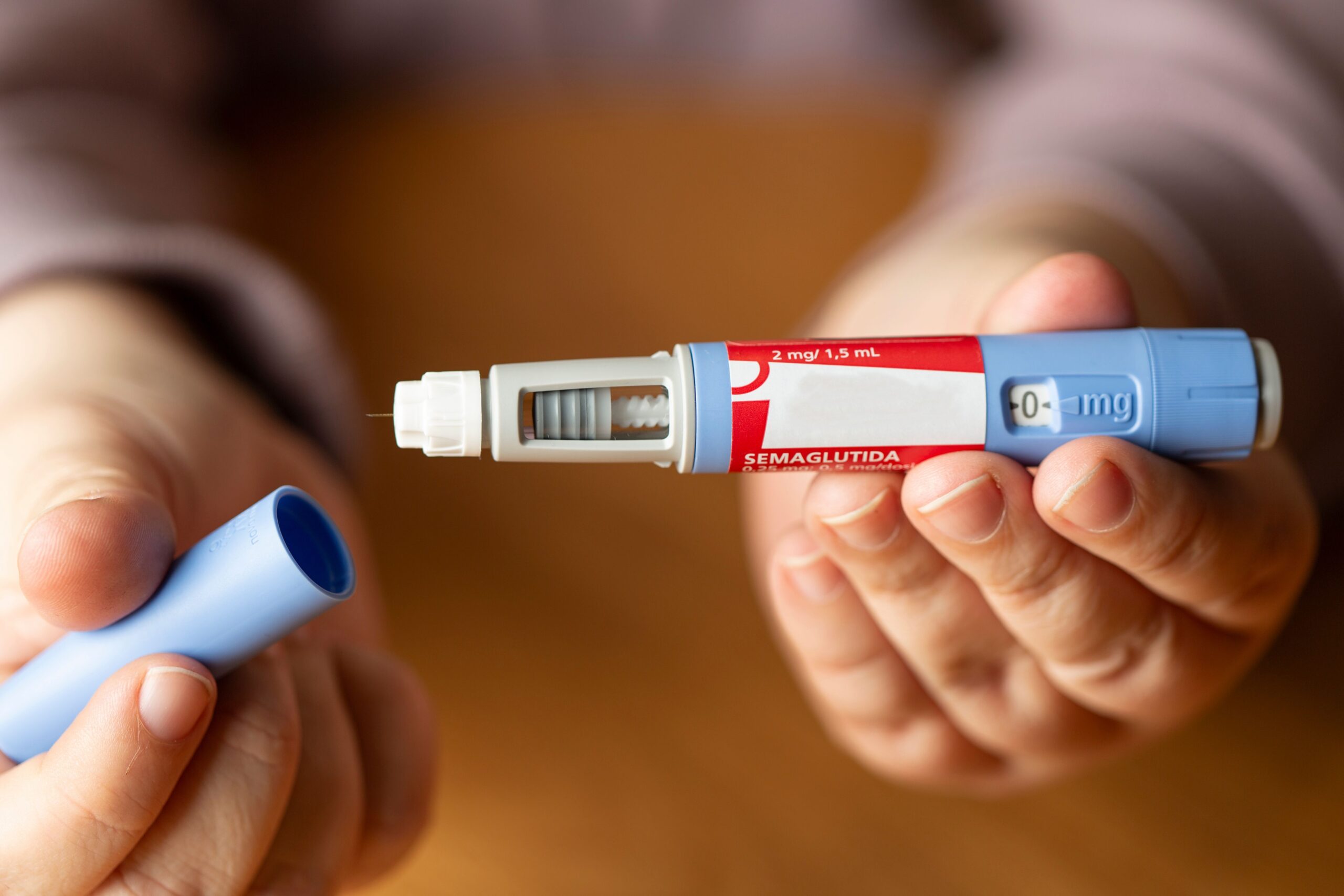Person holding a semaglutide injection pen before physician-supervised GLP-1 weight loss treatment